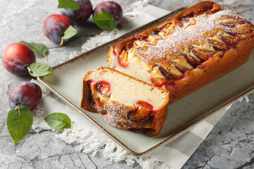 Wall Mural - Fresh Plum Cake with yogurt and olive oil, the sponge is moist and flavourful closeup on the plate on the table. Horizontal