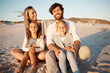 © Lumeez23/peopleimages.com - Parents, children and hug at beach, vacation and smile with care, love or bonding on ground in summer. People, mom and dad with in portrait with kids, family or embrace in sunshine by ocean in Spain