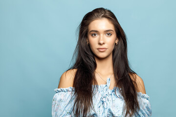 Wall Mural - Brunette Woman Model In Blue Dress On Blue Background Beautiful Girl with Long Hair