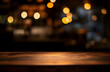 © john - Empty wood table top on blur light gold bokeh of cafe restaurant in dark background