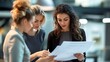 © Pichapob - Female team leader reviewing documents with her colleagues in a contemporary office setting