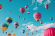 © Nena Ai - Multiple hot air balloons float gracefully in a clear blue sky, creating a stunning and colorful spectacle against a backdrop of clouds, capturing the joy of flight and adventure.