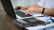 © Mr.Boyz - Businesswoman working on laptop computer, digital tablet and calculator at wooden table in office. Business planning, investment and marketing concept.