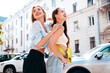© halayalex - Two young beautiful smiling female in trendy summer clothes. Sexy carefree women posing in the street. Positive models having fun, hugging in sunny day. With bright makeup and red lips