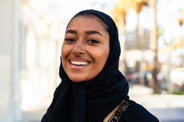 Traditional arab woman wearing emirati abaya outdoors - Beautiful middle-eastern adult female portrait in the city