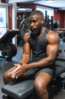 © Uri Prat - Black man sitting on the weight bench putting magnesium in his hands