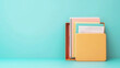 © Piya W. - Colorful folders and papers arranged neatly against a turquoise background, perfect for office or organization themes.