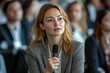 © Kishan - Female manager asking a question from audience while participating in business seminar at convention center, Generative AI