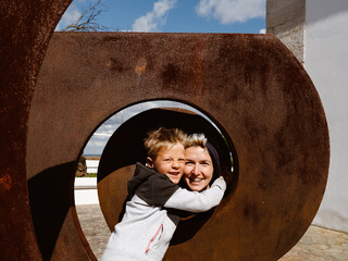 Wall Mural - Funny portrait of happy child hugging happy mother