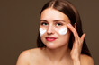 © ibragimova - Personal care for beauty and cosmetics. Facial rejuvenation product collagen beauty people concept. A girl is smearing a cream on her face. A girl uses a facial cream to smear the beauty of face her.