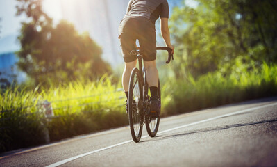 Wall Mural - Woman cycling on summer park trail