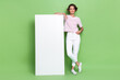 © deagreez - Full size photo of nice young lady lean blank white space billboard promo wear stylish striped garment isolated on green color background