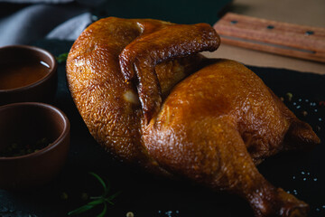 Canvas Print - Half of smoked chicken on dark background