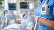 © Pinklife - A healthcare professional wearing gloves is providing medical care by adjusting an IV drip for a patient in a hospital, with medical equipment and monitors visible in the background.