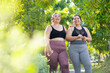 © NVB Stocker - LGBTQ couple.Two smiling sporty young chubby overweight women in sportswear walking in park after workout. fitness sport club, body and health care. Outdoor Activity