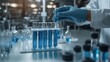 © lililia - A hand in blue gloves carefully holds a test tube filled with liquid while surrounded by other glassware on a laboratory desk