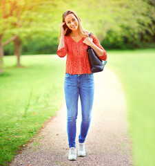 Poster - Woman, walking and portrait on park path, outdoor and eco friendly travel on weekend break in nature. Happiness, smile and holiday in summer for relax, peace and outside for journey with greenery