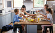 © ReeseBuyout1/peopleimages.com - Happy parents, children and serving breakfast in home for nutrition, food and meal as healthy diet. Family, kitchen table and morning with excited, hungry and together on weekend for bonding in house
