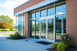© Pics_With_Love - Modern vet clinic exterior with large glass windows and brick facade, surrounded by landscaped greenery, illustrating healthcare and veterinary services environment