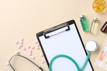 Wall Mural - Pharmacist concept. Flat lay composition with clipboard, stethoscope and pills on beige background, space for text