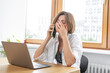 © Vitaliy - Shocked business woman looking at laptop and talking to mobile phone. She discussing problems in business
