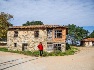 Portrait of pretty young girl in front of stone house