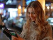 © Fridocha - Woman Smiling While Using a Payment Terminal with a Credit Card
