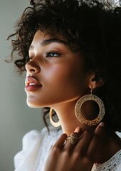 Wall Mural - A woman with long curly hair and gold hoop earrings