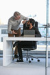 © Caia Image - Businessmen talking in office; Two businessmen looking at digital tablet and talking in modern office at desk