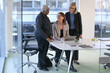 © Caia Image - Businesswomen talking in office; Three smiling businesswomen talking in modern conference room in office