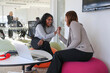 © Caia Image - Smiling businesswomen giving high five in office; Two smiling businesswomen giving high five in modern office