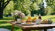 © lililia - A delightful breakfast is set on a wooden table with pillows, surrounded by fruits, milk, honey, coffee, and flowers beneath an apple tree in a sunny outdoor setting
