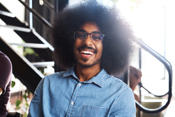 Wall Mural - Happy man, portrait and designer with afro and glasses in creative business or startup at office. Face of young male person, nerd or geek with smile for internship or job opportunity at workplace