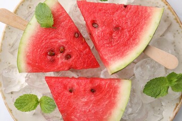 Wall Mural - Pieces of tasty watermelon, ice cubes and mint on table, top view