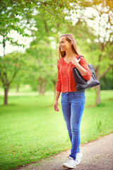 Canvas Print - Walking, woman and happy in park for travel, adventure and freedom for summer with grass. Female person, wellness and smile in nature or countryside for holiday, vacation and calm in woods or outdoor