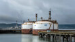 © MPA STUDIO - Industrial hydrogen storage tanks at coastal seaport terminal. Clean energy and green transition concept. H2 containers on pier. Sustainable fuel technology for shipping and transportation solutions