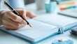 © missisya - A close-up of a hand writing in a notebook with a fountain pen, showcasing productivity and organization in a bright workspace.