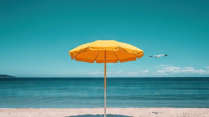 Poster -  A bird flies over a yellow umbrella on a beach beside water