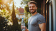 © Alex Tihonov - Handsome young 30s sportive man posing outdoors with bottle of water, smile, looking at camera. Sport, healthy lifestyle concept