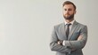 © WS Studio 1985 - A young businessman stands with his arms crossed, exuding confidence and professionalism against a clean, minimalist background.