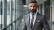 © Najikung - Confident businessman in a tailored suit poses in a modern office setting, exuding professionalism and style.
