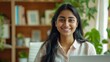 © Johannes - Happy young Indian business woman sitting at desk with laptop Professional online teacher coach in Smile School Advertise virtual student classes Teach a webinar on distance education. Portrait.