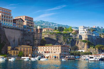 Wall Mural - Sunny day in Sorrento, Italy, with multicolored luxury hotels on cliffs above peaceful marina with boats. Sorrento attract lot of tourists from all over world.