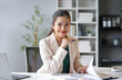 © Crystal - Businesswoman is smiling while reviewing documents and holding a pen at her clean and organized desk