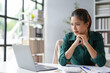 © Crystal - Young asian businesswoman is frowning and looking worried while working on a laptop in her office