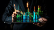 © Mahemud - A businessman holding a tablet and showing holographic graphs and stock market statistics