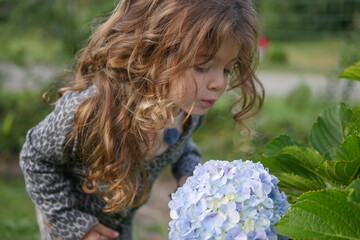 Child in the garden smelling flowers