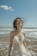 Caucasian woman in white dress walking on the beach.