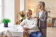 © Studio Romantic - Portrait of calm peaceful senior woman hugging elderly man sitting at home. Mature married couple looking at the window enjoying being together. Relationship in retirement concept.