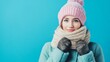 © Kharkovich - Woman in winter clothing with pink hat and scarf on blue background